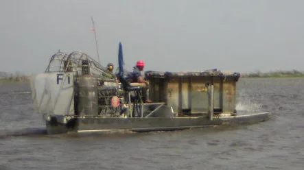 Wide work airboat carrying equipment on open shallow water