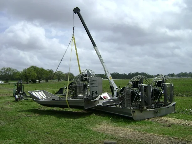 Crane-equipped Faucheux airboat with its boom raised